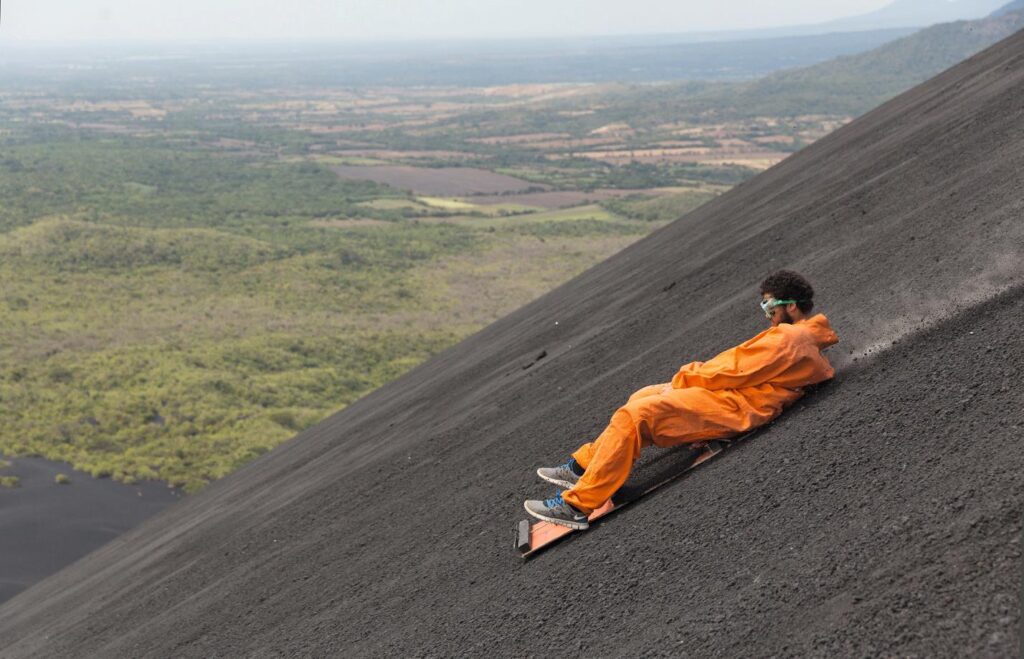 A man is volcano boarding down Cerro Negro.