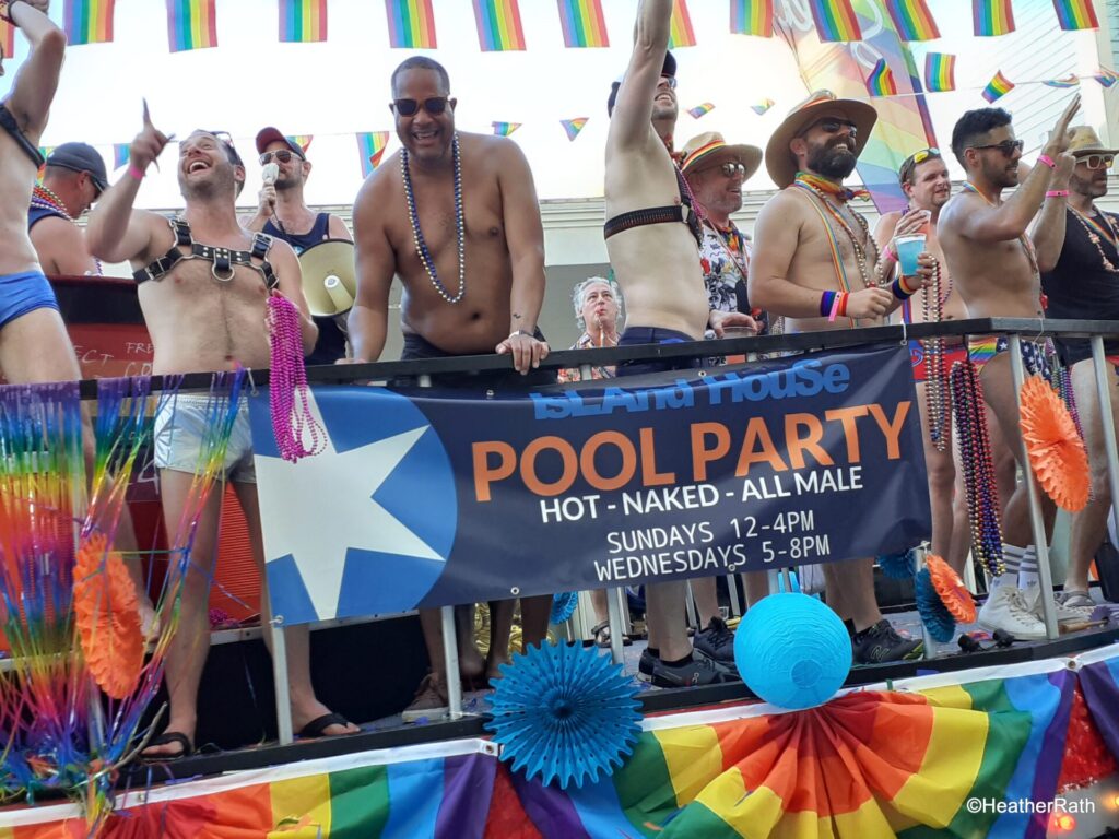 Pride parade float advertising all male pool party