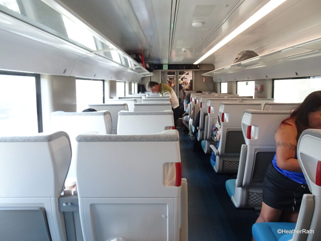 photo inside standard train car, seats one way facing