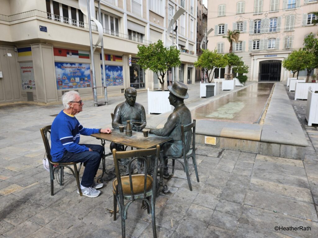 Statue of bronze figures, one representing the local actor Daniel Auteuil who played Cesar the bar-owner in Marcel Pagnol's Marius, Fanny, César trilogy 