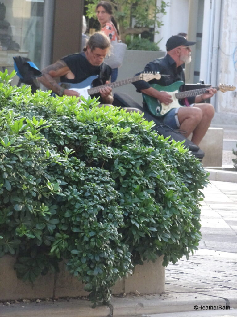 2 outdoor troubadours providing street music to passerbys