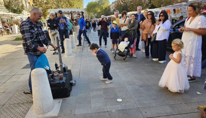 We came across this scene as we spend a day in Aix en Provence A liitle boy dances with the puppets as his sister watches at the Cours Mirabeau Market