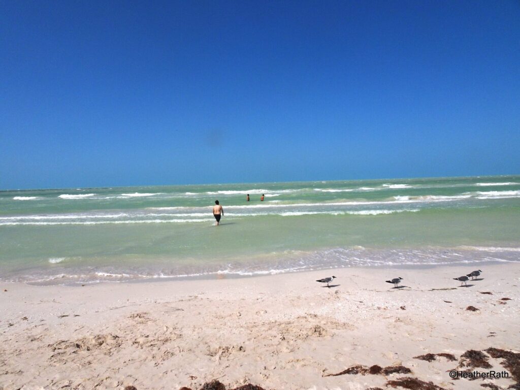 3 men braving the waves ar Cancunito Beach