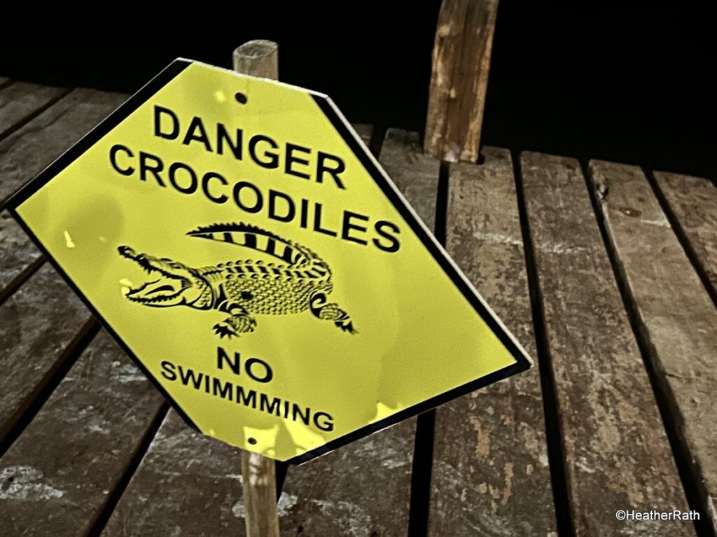 pic of sign at the end of our table advising no swimming due to nearby crocodiles at Hotel Rio Lagartos